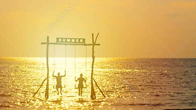 4K. silhouette of happy couple enjoy swaying with the swing over the sea during sunset time. happy summer vacation