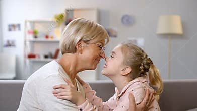 Female kid and granny nuzzling, family generations and connection, closeness