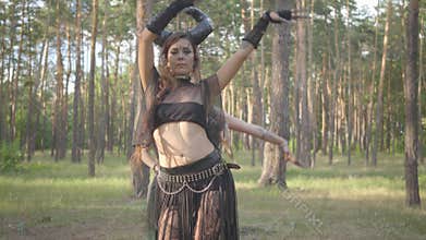 Group of women dancers with make-up and in mystical fabulous costumes dancing groovy dance in the forest. Forest fairies