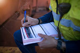 Construction coal miner supervisor conducting safety checking on job hazards analysis on hot work permit before sign off