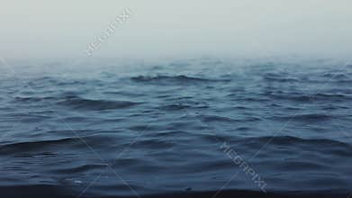 Sea waves. Fog above blue ripple water. Foggy morning