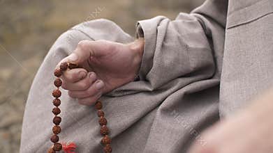 Hindu man meditating with beads