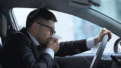 Business driver sneezing, suffering from runny nose, seasonal allergies, cold
