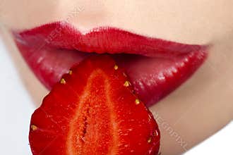 Woman`s mouth with strawberry