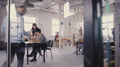 Multiethnic team working in modern trendy office. Happy young smiling creative millennials work in light coworking 4K.