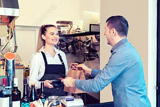 Customer paying to go order with credit card in small eatery
