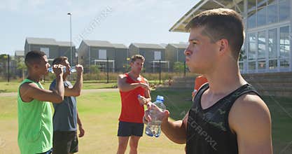 Men drinking water after training on sunny day