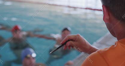 Swimming coach talking to swimmers