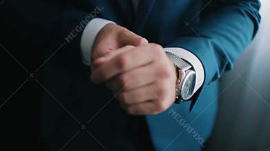 Close-up of a successful man is putting on a watch. Men`s hand with a watch. Wedding day.