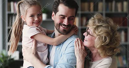 Portrait of happy three generations family enjoying tender moment indoors.