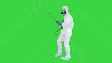 Man wearing an NBC personal protective equipment spray disinfectant and dancing on a Green Screen, Chroma Key.