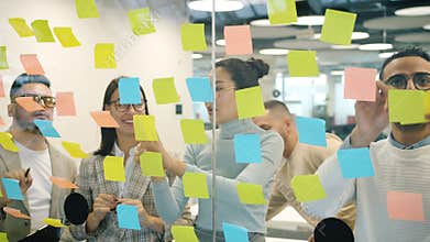 Slow motion of coworkers working with colorful sticky notes brainstorming in office