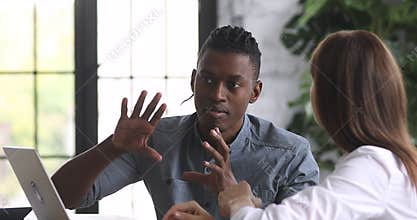Young multiracial diverse colleagues discussing working issues.
