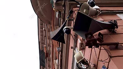 Retro loudspeakers and modern surveillance cameras on the corner of the house.