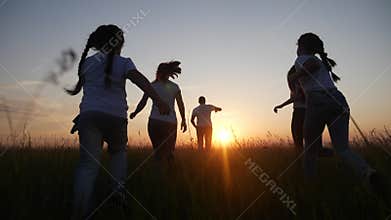 Happy family children kids together run in the park at sunset silhouette. people in the park concept mom dad daughter
