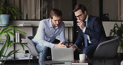 Two focused business partners discussing corporate software application.