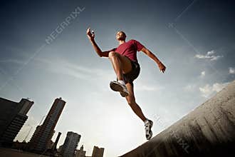 Hispanic man running and jumping from a wall