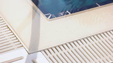 White edge of swimming pool on a sunny day.