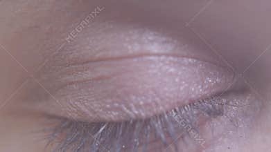 Close-up of female eye. Macro detailed shooting. Woman blinking slowly, looking in camera.