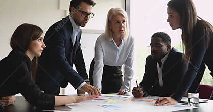 Serious multiracial team with female manager brainstorming on paperwork