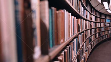 Stedicam shot. Camera moves forward along shelves filled with paper books. The huge round library in Stockholm, Sweden