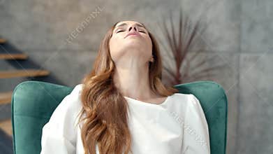 Tired business woman finishing work at home office. Girl relaxing on chair.