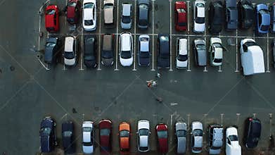 Drone footage people moving at parking. Copter flying above parking at city