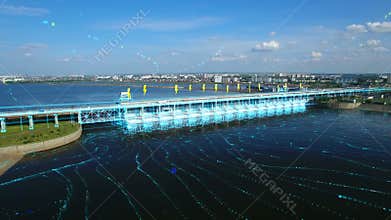An aerial view a of the hydroelectric power station with cars traffic moving over the bridge and flowing river. 3D