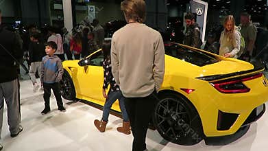 Looking at the Bright Yellow Acura Sports Car at the Auto Show