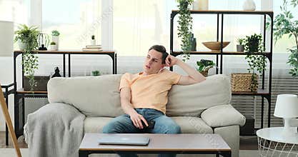 Man Upset from boredom with phone on sofa