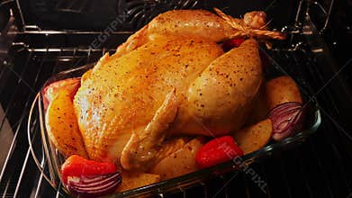 Process of cooking whole chicken with potatoes in the oven Close up. Time lapse