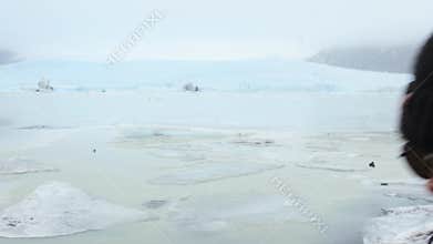 Woman tourist show heart symbol sign on Fjallsjokull glacier lagoon in Iceland. Save earth, love planet concept, reduce carbon