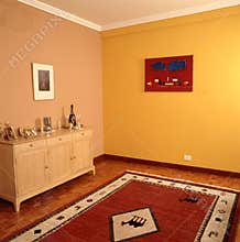 home interior living room without table and chairs with carpet yellow painted wall pictures and wooden floor without people