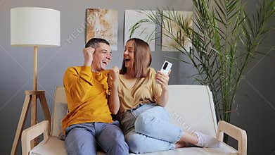 Digital abode. Smart relationships. Internet connection. Leisure technology. Overjoyed adult couple using phone at home while