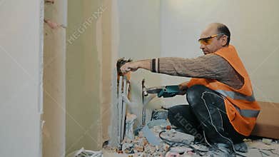 A builder plumber lays water pipes in a bathroom during renovations in a house.