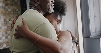 Happy senior african american couple embracing in ktichen in slow motion