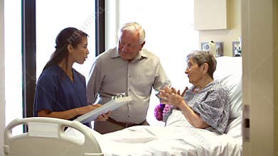 Nurse Talking To Senior Couple In Hospital Room