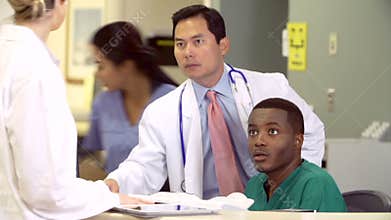 Medical Staff Working At Busy Nurses Station
