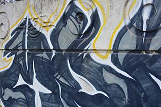 Graffiti depicting the word MAM on white, gray concrete fence.