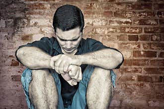 Grunge image of a depressed and lonely young man