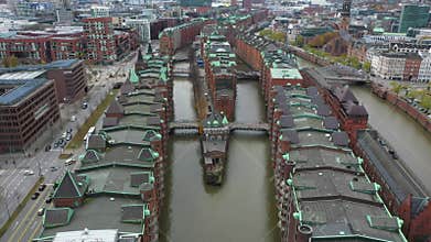 Old red-brick buildings in Speicherstadt along a canal with bridges. Flight through the Warehouse district, downtown in Hamburg,