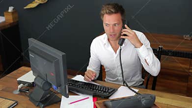 Hotel Receptionist Using Computer And Phone