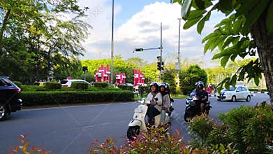 Urban Street with Scooters and Cars in Lush Green Surroundings