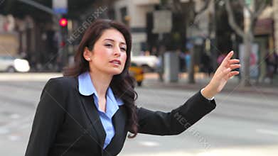 Businesswoman Hailing Taxi In Busy Street