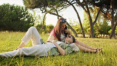 Young couple relaxing in park, woman gently touching man's hair