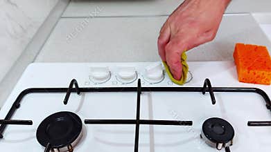 Polishing Stove Knobs with Sponge: A Quick Kitchen Cleanse