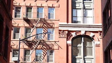 New York City building architecture, Manhattan. Residential house exterior. Red brick, fire escape.