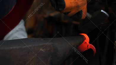 Blacksmith hammering hot iron