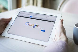 Woman holding iPad showing google search page