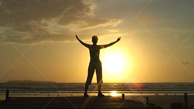 Woman doing relaxation exercises at sunrise